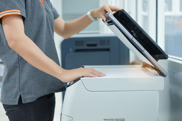 Bussiness woman Hand putting a document paper into printer scanner or laser copy machine in office