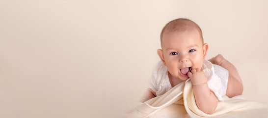 small cute funny baby infant smiling happily and fingers in mouth sore
