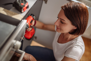 Wall Mural - Woman working on a new kitchen installation