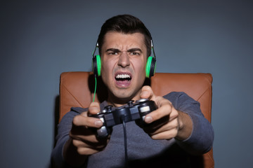 Young man playing video game at home in the evening