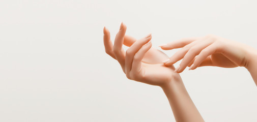 closeup image of beautiful woman's hands with light pink manicure on the nails. skin care for hands,