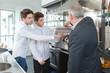 © auremar - young waiters learning to use coffee machine