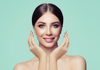 Wall Mural - Attractive young woman with healthy skin holding her hands near face and smiling.