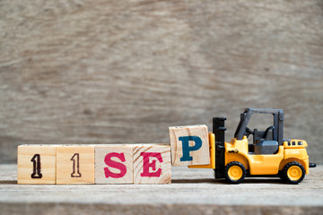 Wall Mural - Toy forklift hold block P to complete word 11 sep on wood background (Concept for calendar date in month September)