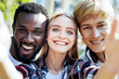 © Viacheslav Yakobchuk - One more shot. Portrait of multicultural friends smiling while spending their day together and posing for a selfie outdoors.