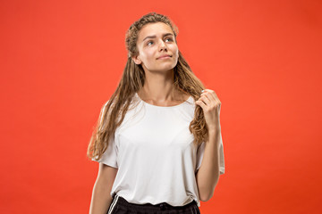 Wall Mural - The happy woman standing and smiling against red background.