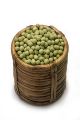 Wall Mural - Green peas in cane basket isolated on white background