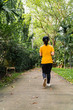© somesense - The back of a woman jogging in a park.