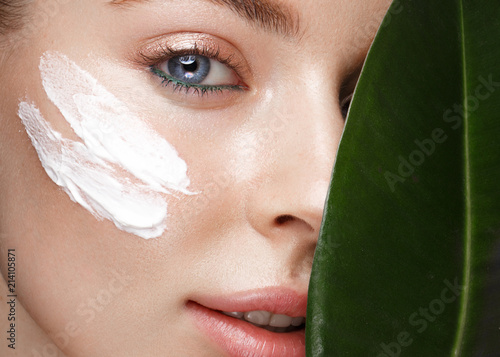 Cuadros en Lienzo Beautiful fresh girl with cosmetic cream on the face, natural make-up and green leaves