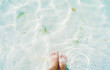 Close-up image of woman's feet on the bottom of the sea