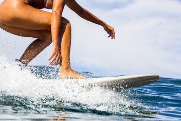 Wall Mural - Closeup of beautiful young Sporty girl in a bikini swimsuit ride big wave with lot of splashes. Fit surfer woman surfing in Mauritius in the Indian Ocean on the transparent waves. Outdoor Active Life.