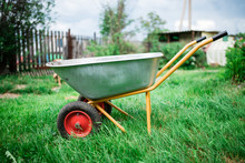 Work In The Garden Wheelbarrow On The Front Of The Garden. Gardening Tools: Worn Trolley 