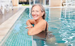 Vitale Senior Frau am Beckenrand vom Pool