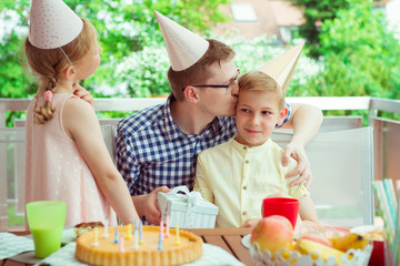 Wall Mural - Portrait of happy young family celebrate birthday at colorful decorated terrace