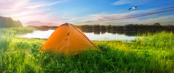 Wall Mural - orange tent on the shore of the lake