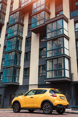 Wall Mural - New multi-storey residential building with car parked in front. Modern house