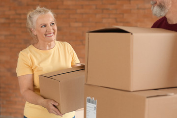 Mature couple with moving boxes at new home