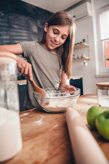 Wall Mural - Girl mixing flour and sugar into bowl