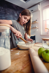 Wall Mural - Girl mixing flour and sugar into bowl