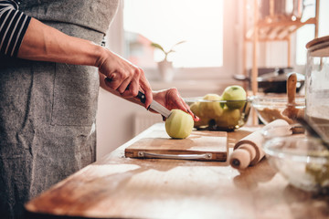 Wall Mural - Woman cutting apples in the kitchen