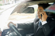 © MIND AND I - Successful businessman sitting behind the wheel of a car
