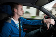 Junger männlicher Autofahrer ganz entspannt am Steuer seines Autos