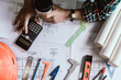 © Akira Kaelyn - Concept architects, Hand of asian young woman engineer using calculator for calculation number of structural materials  architects On the desk with a blueprint in the office, Vintage Tone