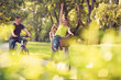 © Lucky Fenix - Family sport and healthy lifestyle. Happy father and mother with kid on bicycles having fun in park..