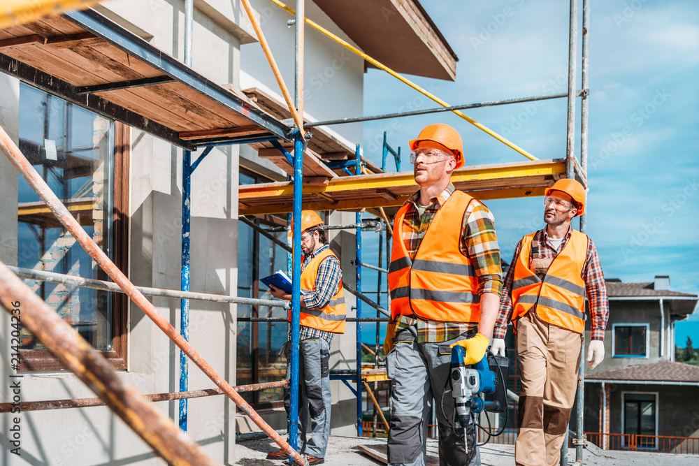 group of handsome builders working together at construction site Stock ...