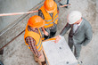 © LIGHTFIELD STUDIOS - high angle view of builders and architect discussing blueprint at construction site