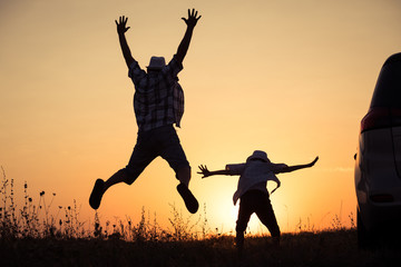 Wall Mural - Father and son playing in the park at the sunset time.