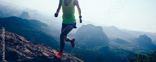 Fotografía woman running on mountain top cliff edge