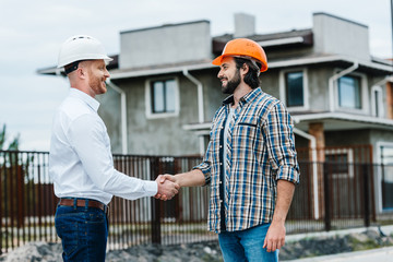 Wall Mural - handsome architects shaking hands at construction site