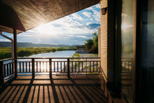 Scenic View Of Beautiful Sunset Over River From Wooden Terrace