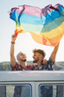 © ADDICTIVE STOCK - Gay couple in van holding LGBT flag
