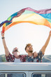 © ADDICTIVE STOCK - Gay couple in van holding LGBT flag