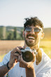 © ADDICTIVE STOCK - Cheerful man with photo camera in nature