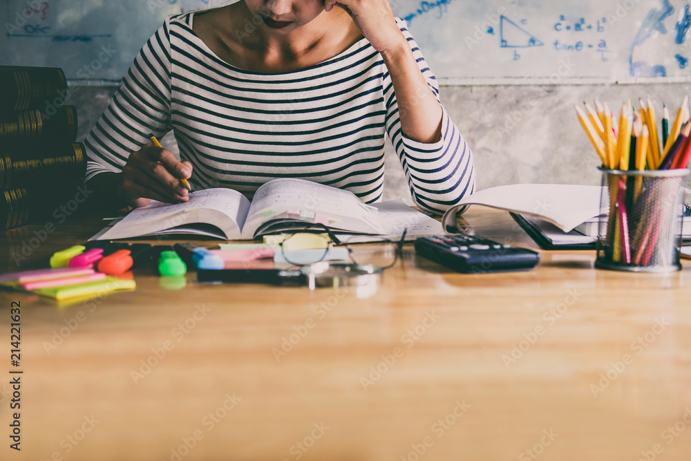 Young student sitting at desk in home studying and reading, doing homework and lesson practice preparing exam to entrance, education concept - obrazy, fototapety, plakaty 