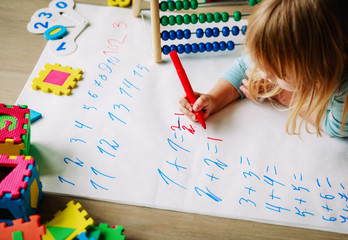 Wall Mural - little girl learn to write and calculate numbers