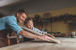 Smiling father and son in carpentry