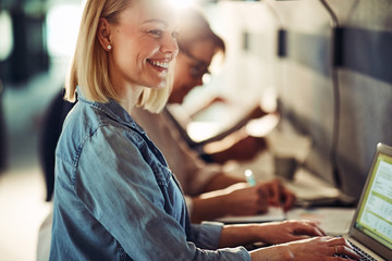 Smiling young designer working with colleagues at an office tabl