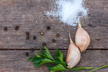 garlic salt and pepper lying on a wooden background space for lettering