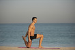 © Paul - A handsome muscular caucasian white European male performs a yoga exercise pose on the beach on a summer morning.