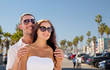 © Syda Productions - travel, tourism and relationships concept - happy smiling couple in sunglasses over venice beach background in california