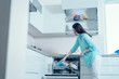 © Руслан Галиуллин - Low angle, a young woman pulls clean dishes from the washing machine