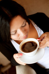 Wall Mural - young woman sitting in a cafe drinking coffee