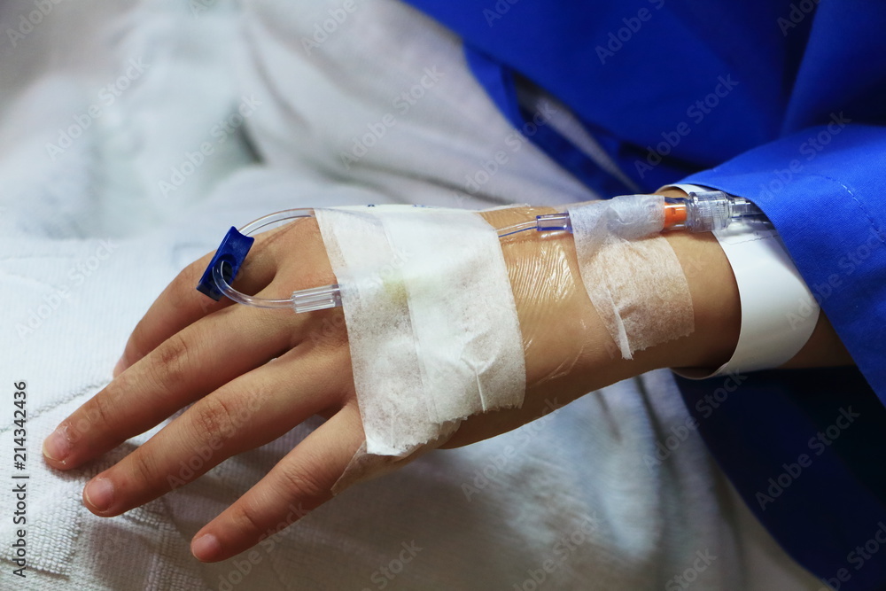 The woman patient in the hospital in blue dress in bed. Seeing the left  hand was intravenous injection by dropping bottle. Stock Photo | Adobe Stock
