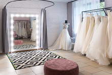  Collection Of Wedding Dresses In The Shop. Wedding Salon Interior. Large Mirror