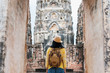 Asian tourist woman take a photo of ancient of pagoda temple thai architecture at Sukhothai,Thailand. Female traveler in casual thai cloths style visiting city concept.