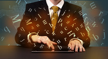 Young Man In Suit And Formal Clothing Typing With Letters Around